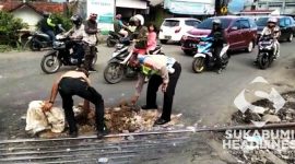 Polisi dan warga urug jalan rusak. l Istimewa