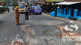 Anggota kepolisian saat menunjukan jalan rusak penyebab kecelakaan. l Dok. sukabumiheadlines.com
