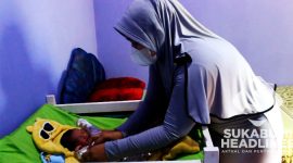 Bidan Ellya Yuningsih saat merawat bayi perempuan yang ditemukan di teras rumah warga Cidahu. l Dok. sukabumiheadlines.com
