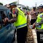 Polisi membagikan air mineral kepada pengendara yang terjebak kemacetan di interchange Tol Bocimi Seksi 2, Parungkuda. l Istimewa
