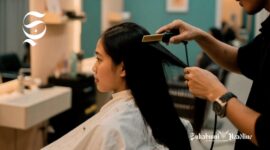 Seorang wanita sedang memotong rambutnya yang panjang - sukabumiheadline.com